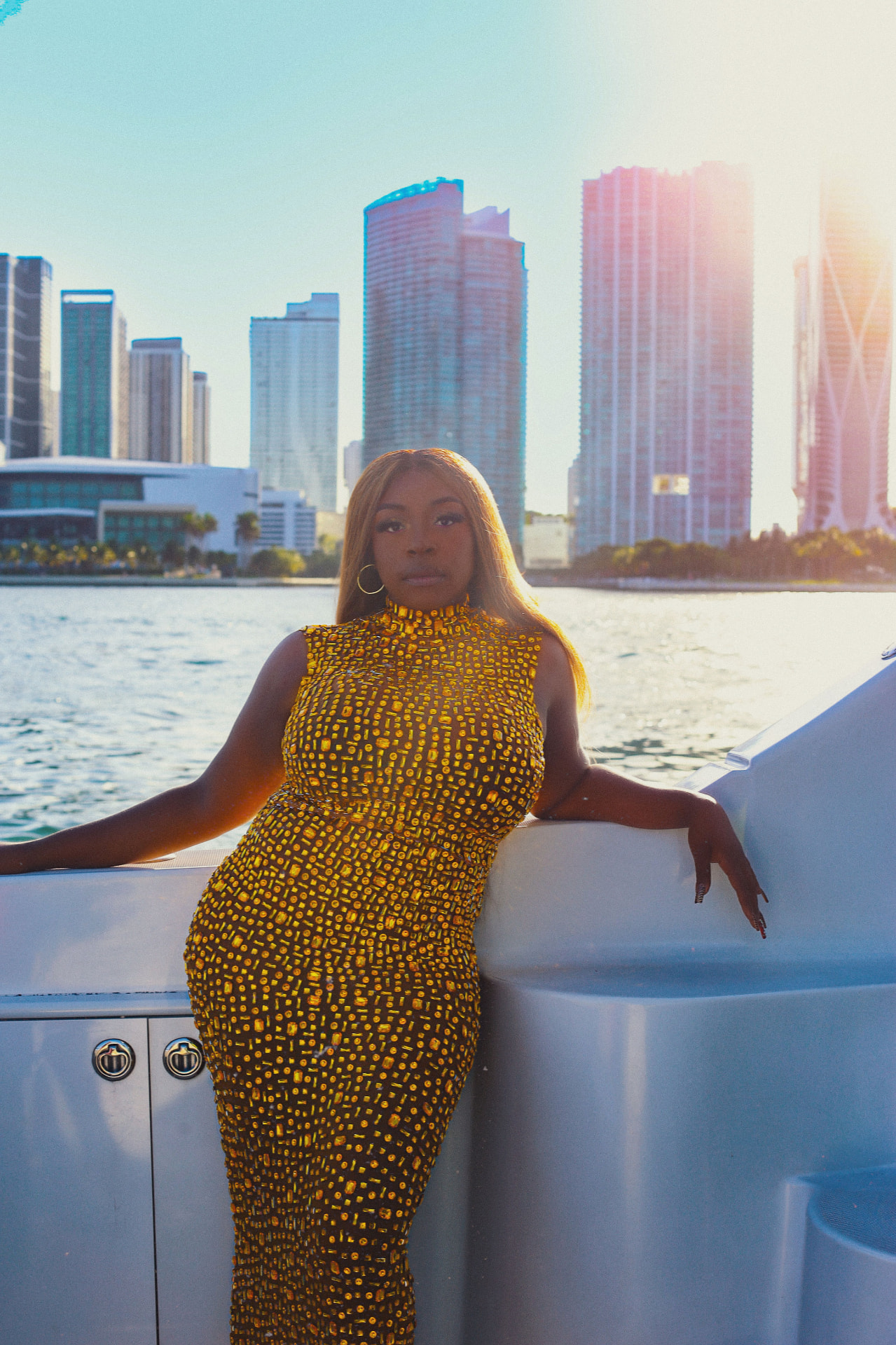 Keke Nova on a yacht in a gold embellished dress