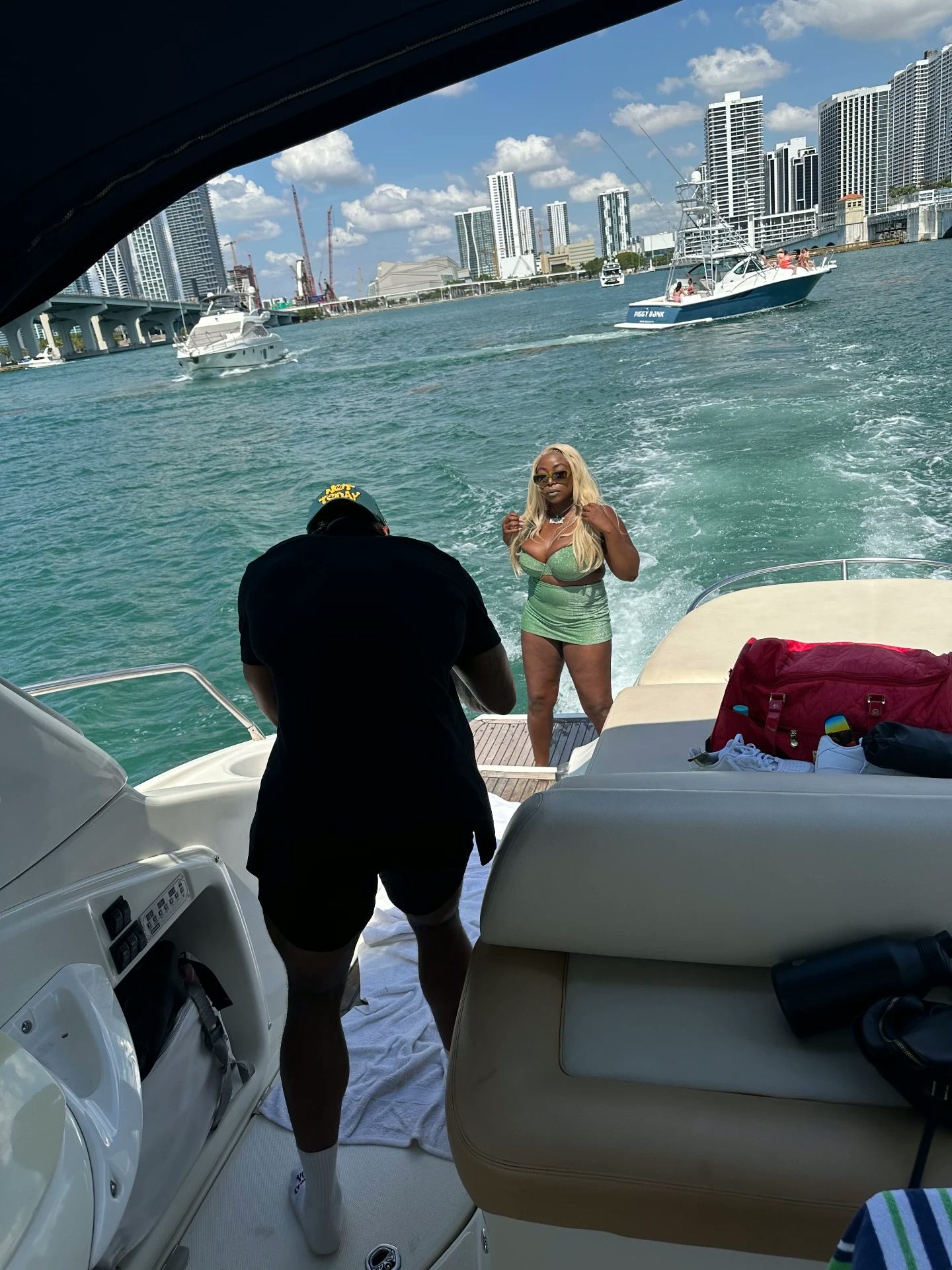 Keke Nova on a yacht in a shimmering green outfit