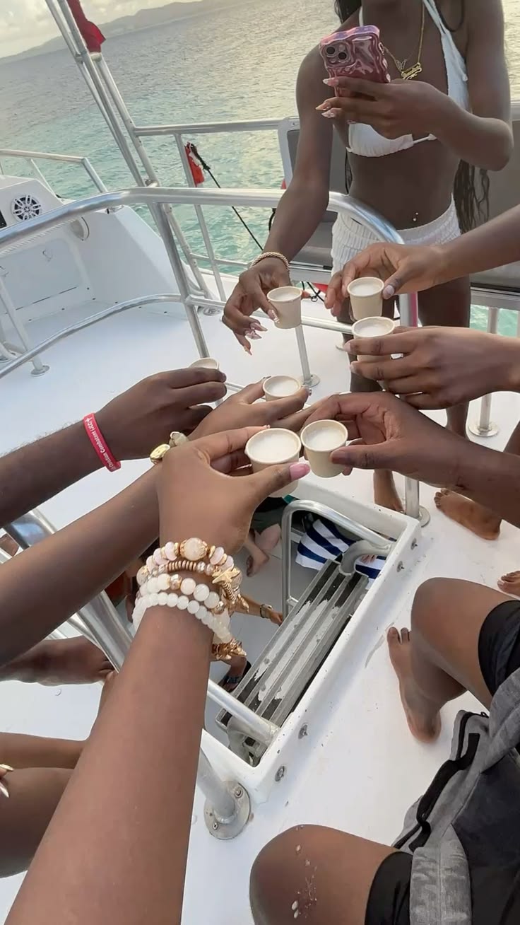 Members toasting cups together on the yacht deck